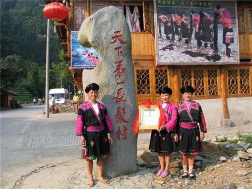 天下第一长发村妇女在石碑前。
